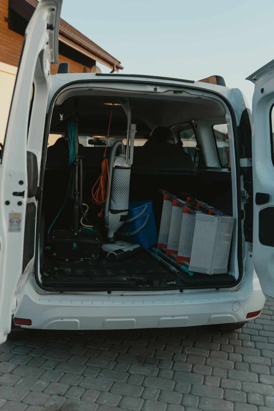 A service vehicle loaded with cleaning machines, buckets and ladders
