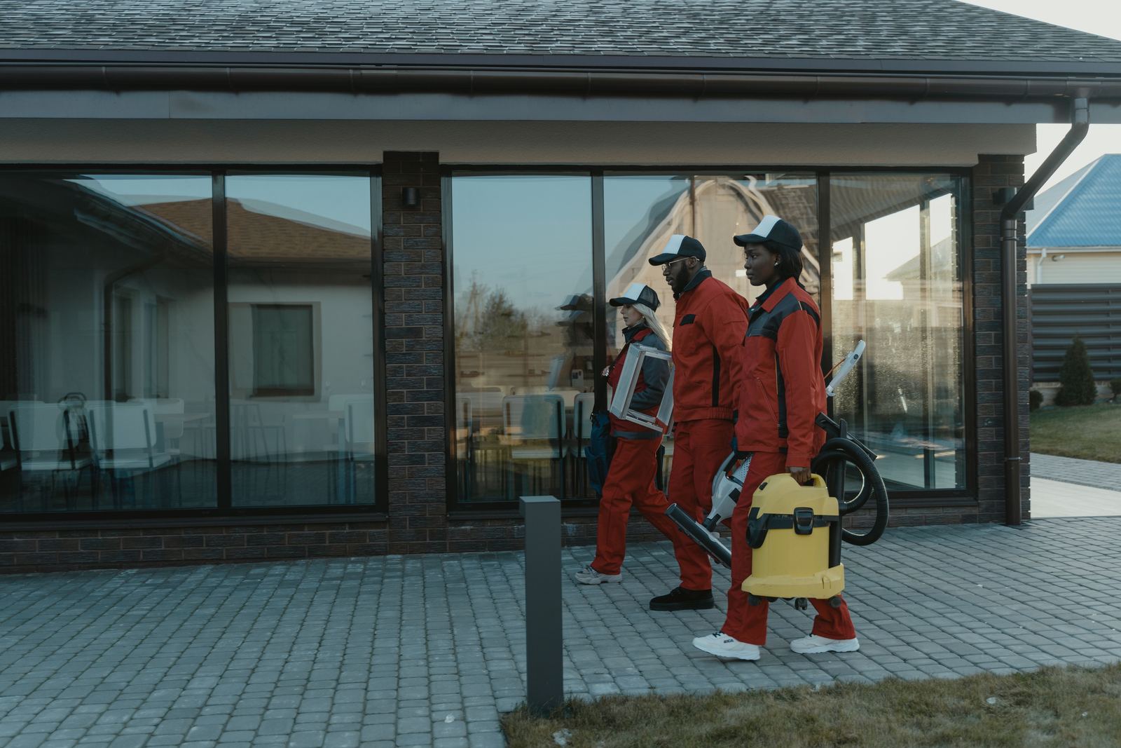 A uniformed team carrying cleaning equipment to a client's building